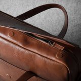 Brown leather bag on a textured gray background
