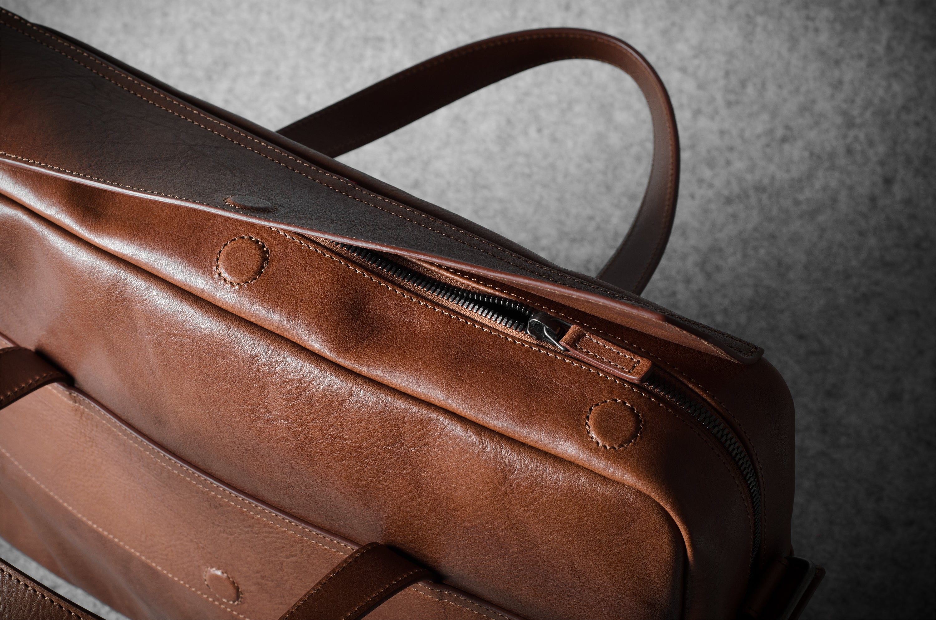 Brown leather bag on a textured gray background