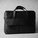Black leather briefcase on a gray background