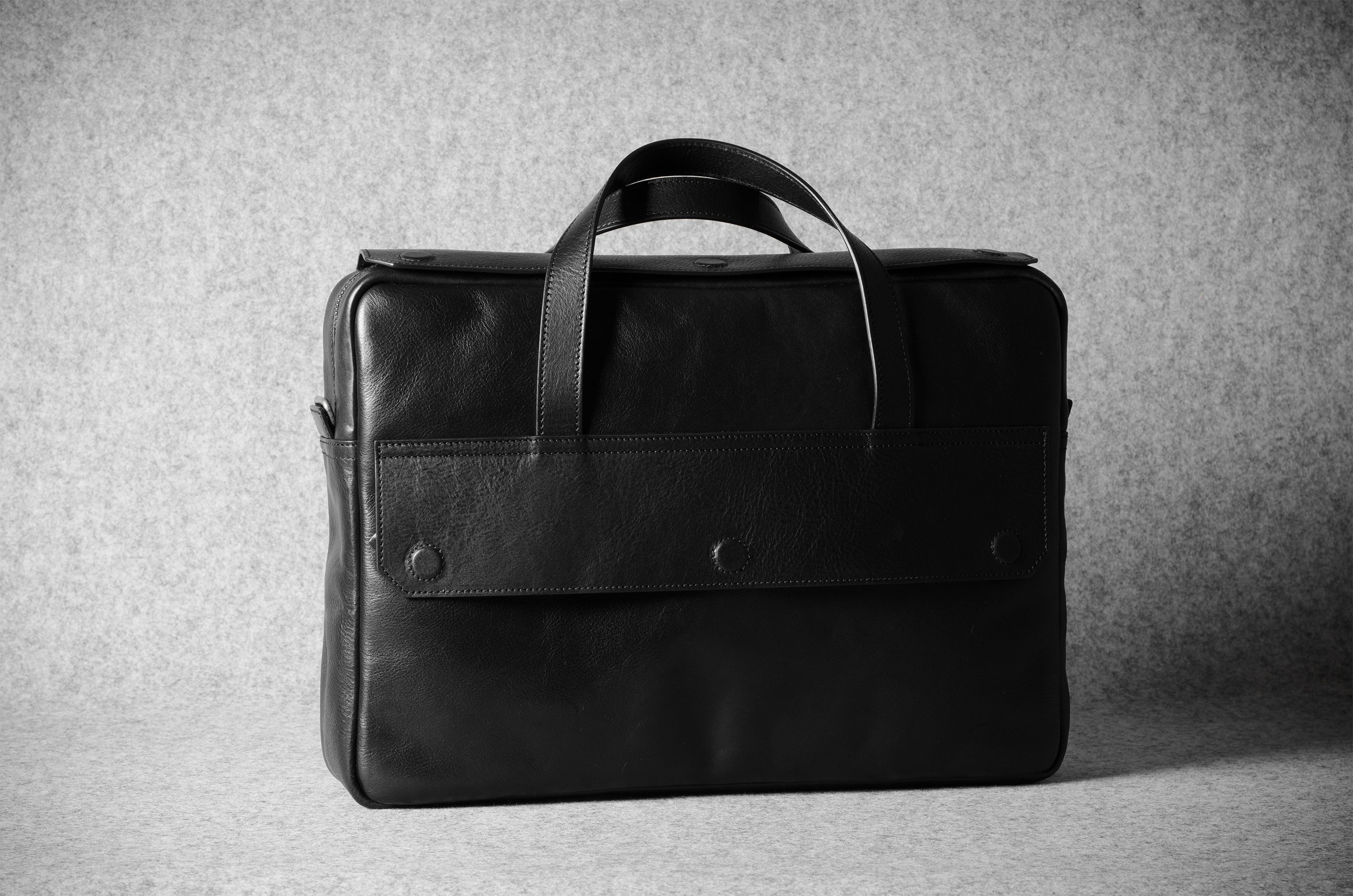 Black leather briefcase on a gray background