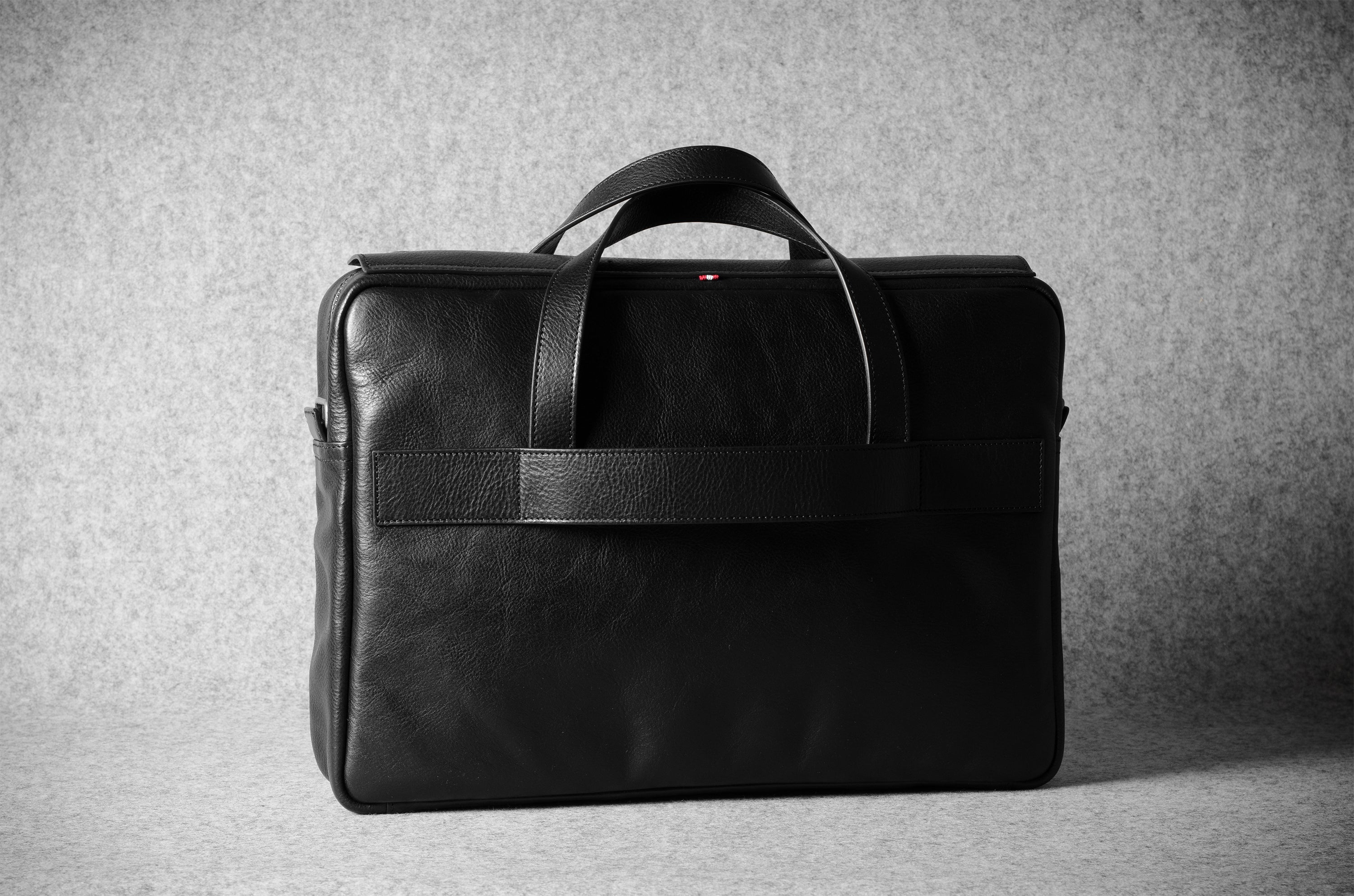 Black leather briefcase bag on a gray background