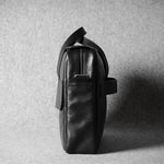 Black leather bag on a textured gray background