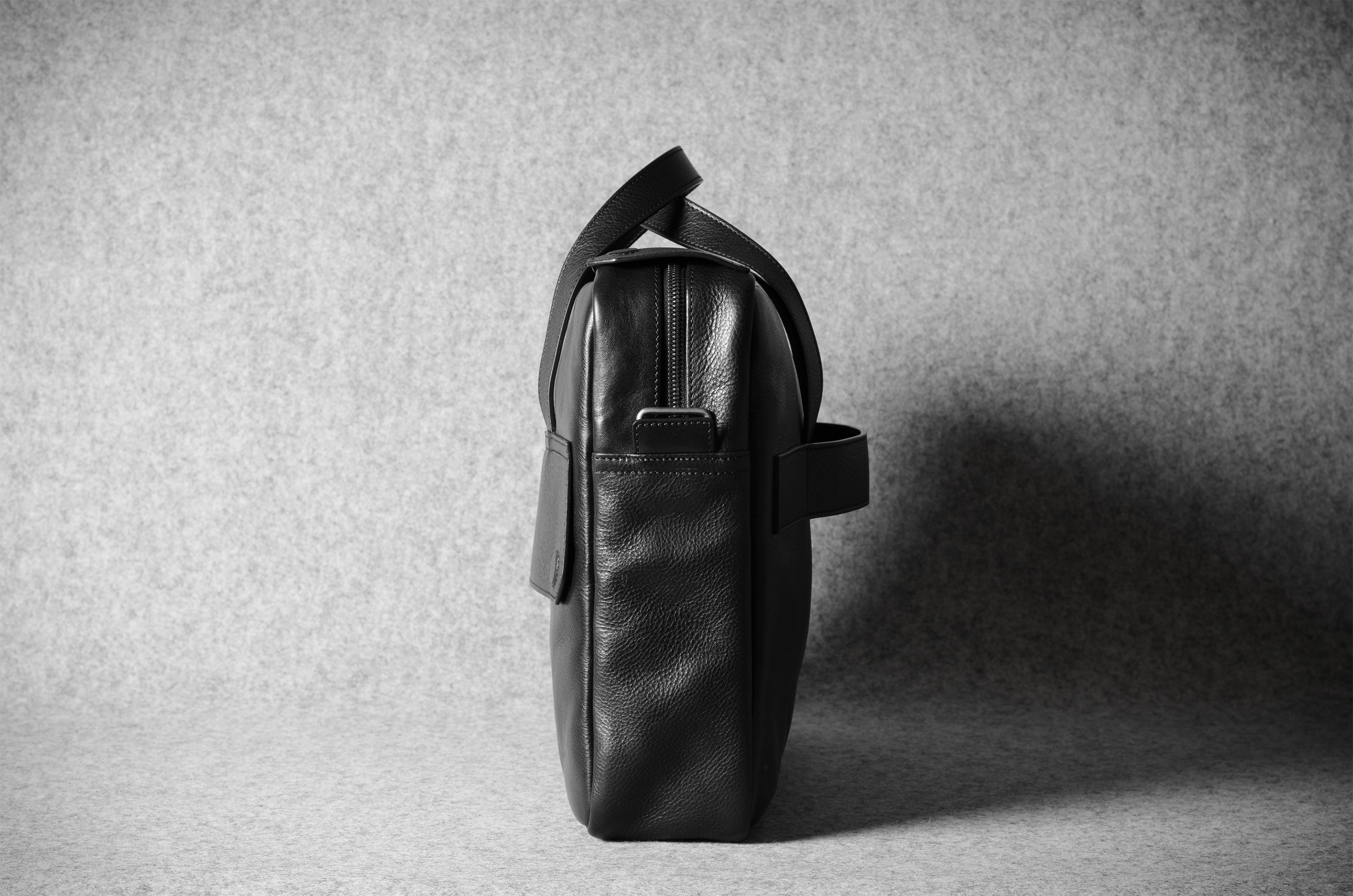 Black leather bag on a textured gray background