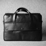 Black leather briefcase on a textured gray background