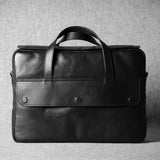 Black leather briefcase on a textured gray background