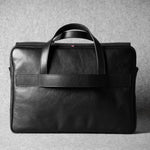 Black leather briefcase on a gray background