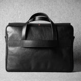 Black leather briefcase on a gray background