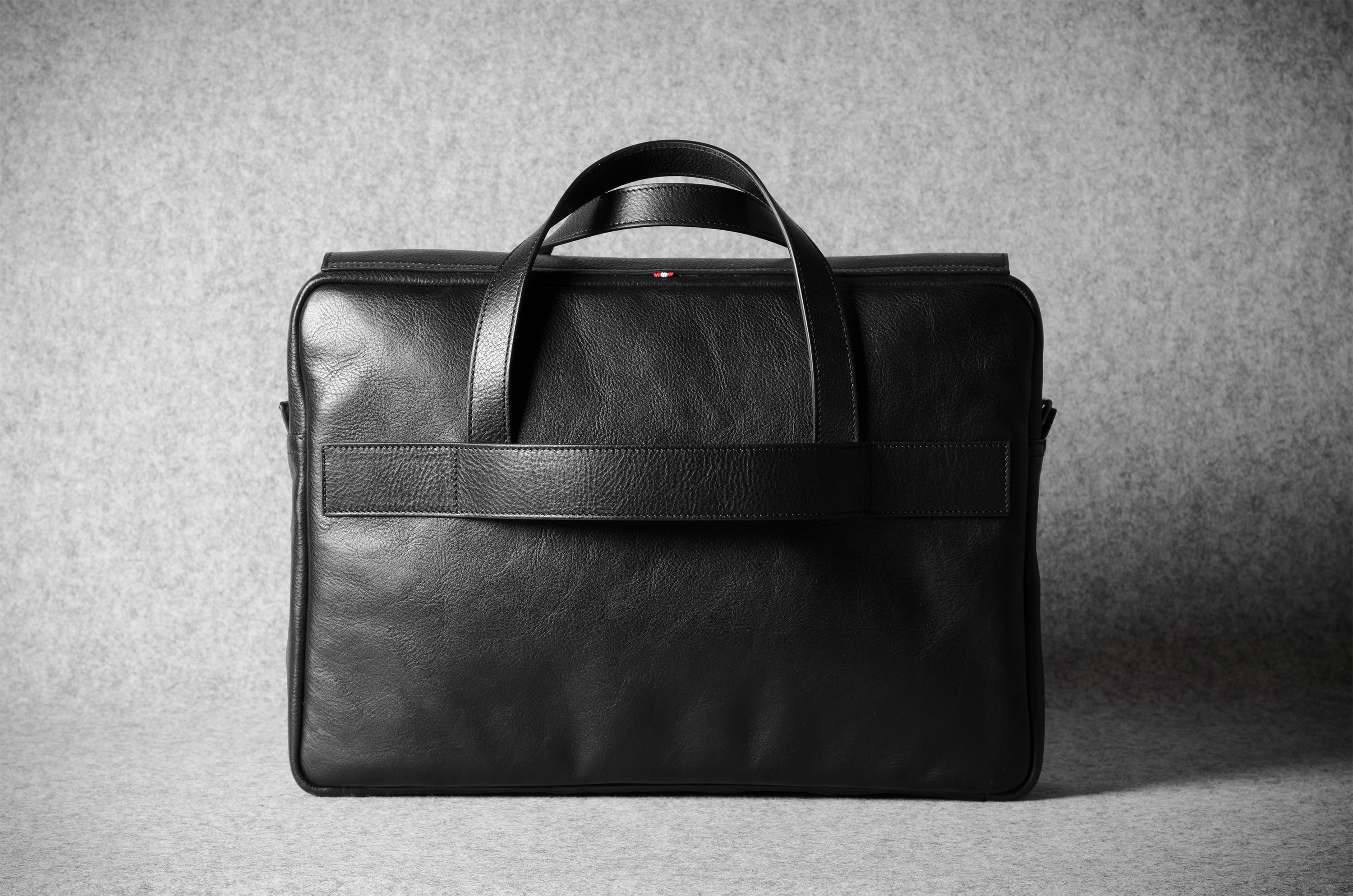 Black leather briefcase on a gray background