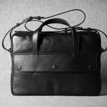 Black leather briefcase on a textured gray background