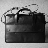 Black leather briefcase on a textured gray background