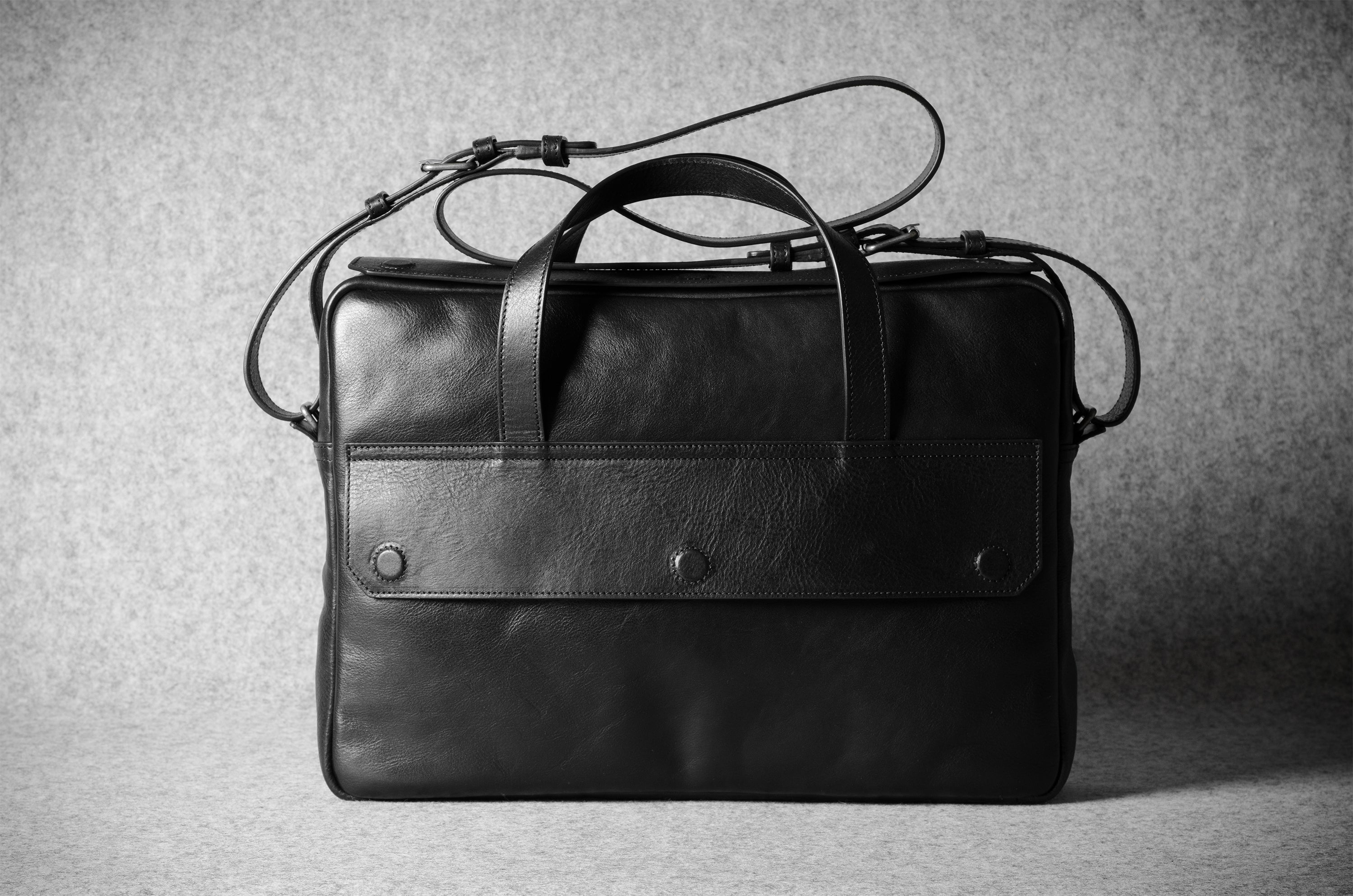Black leather briefcase on a textured gray background