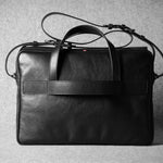 Black leather briefcase on a textured gray background