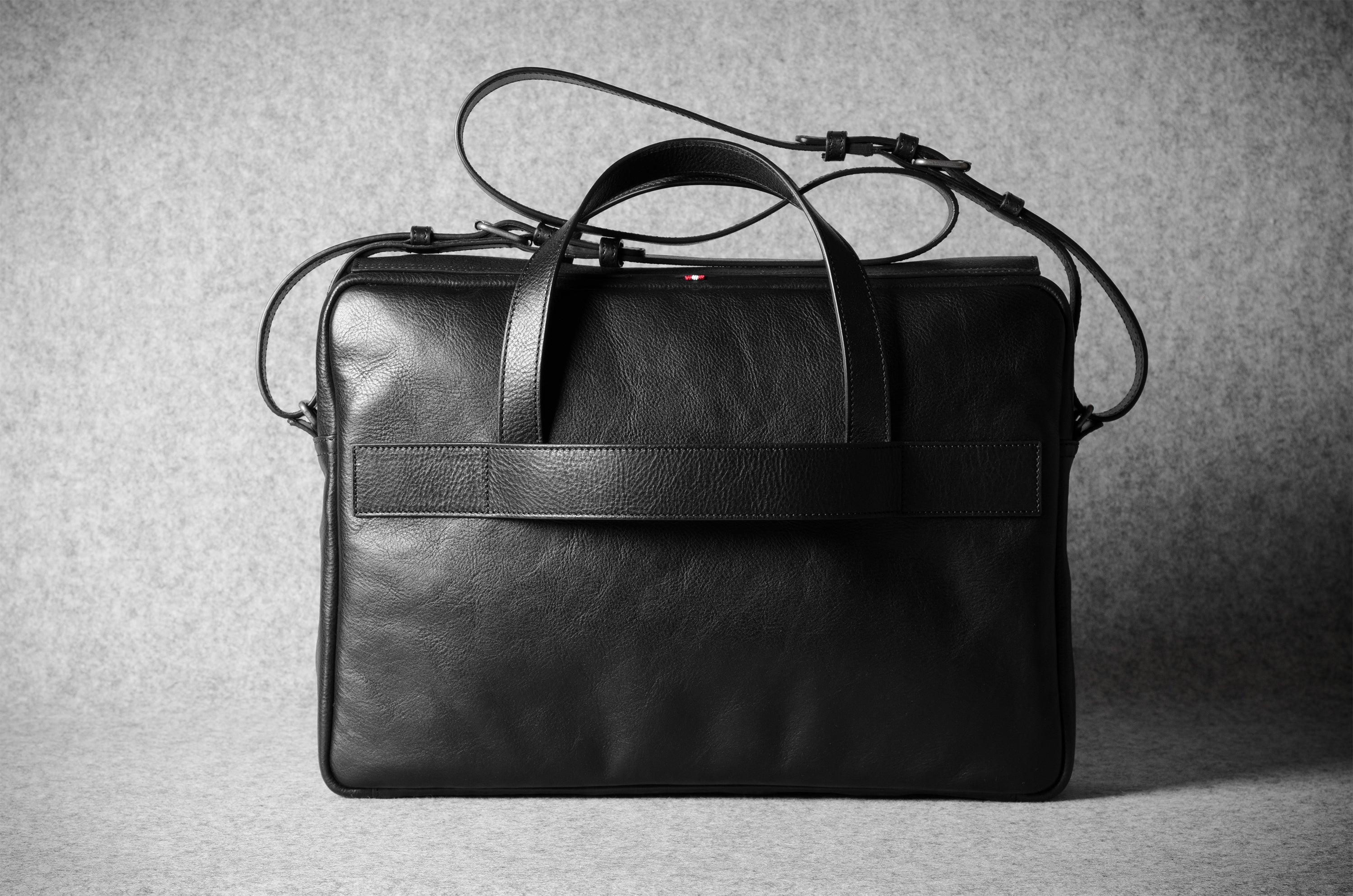 Black leather briefcase on a textured gray background