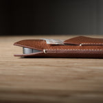 Brown leather  iphone case on a wooden surface with a blurred background