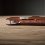 Brown leather  iphone case on a wooden surface with a blurred background