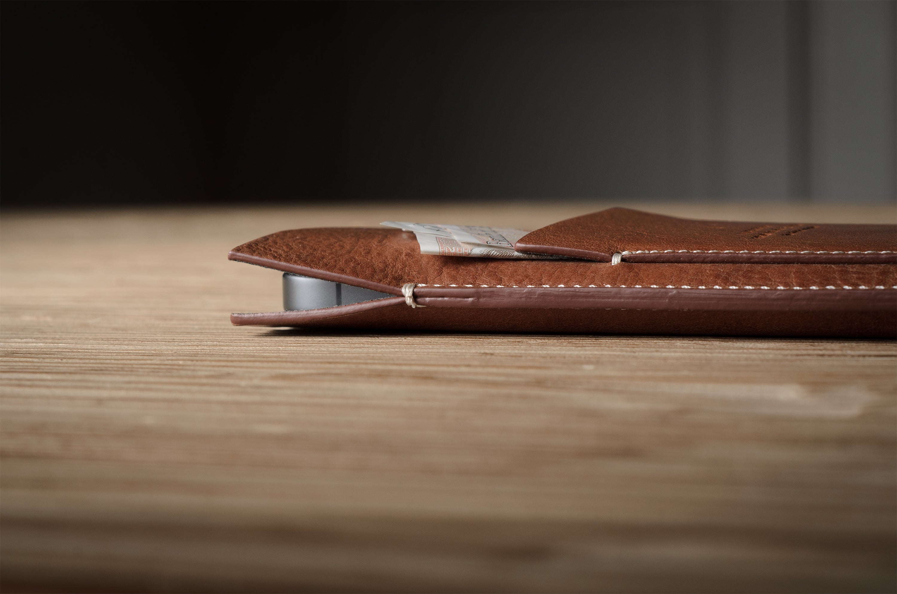 Brown leather  iphone case on a wooden surface with a blurred background