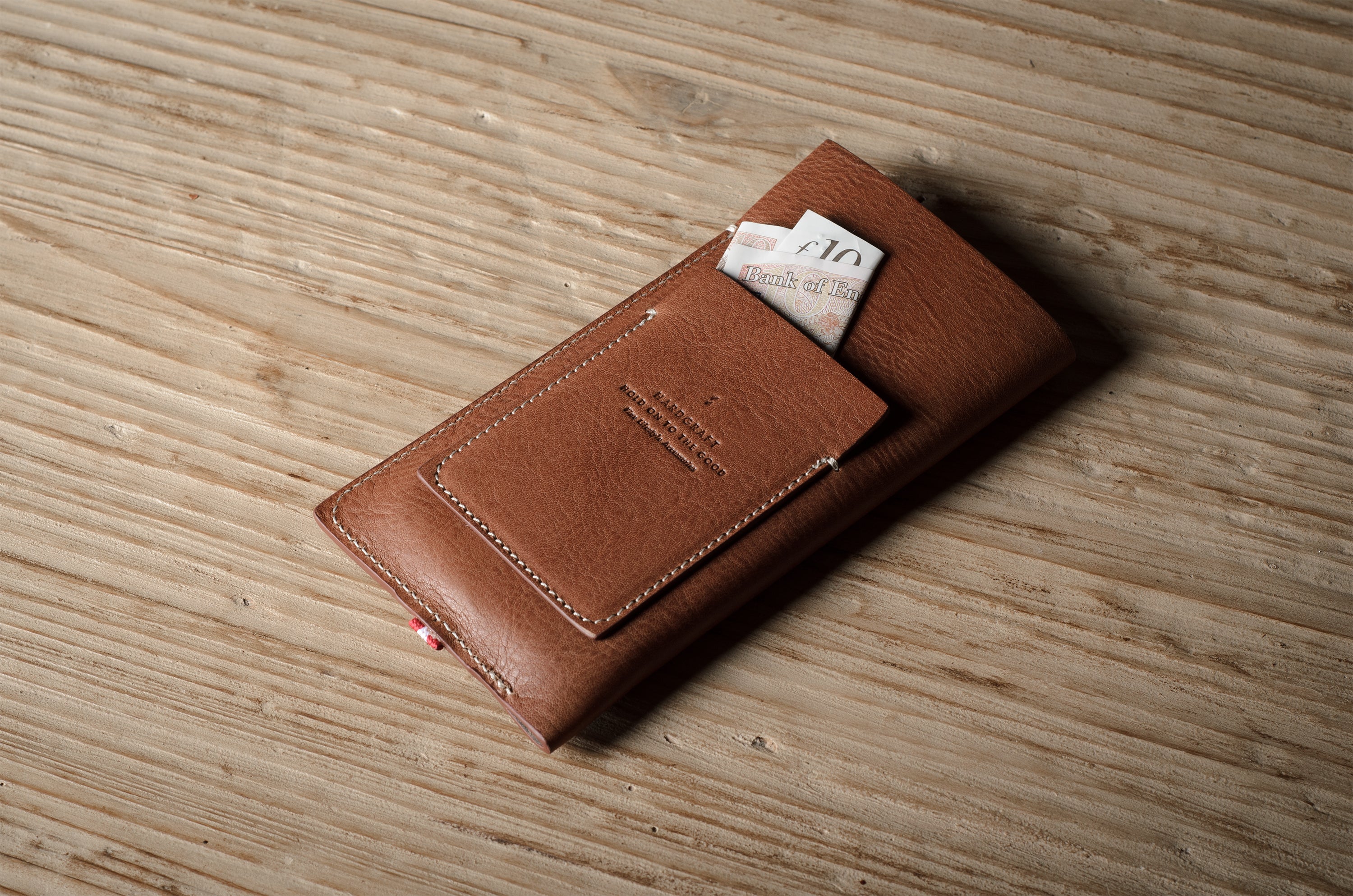 Brown leather  iphone case with a card on a wooden surface