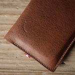 Brown leather iphone case on a wooden surface