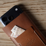 Brown leather iphone case with a card pocket on a wooden surface
