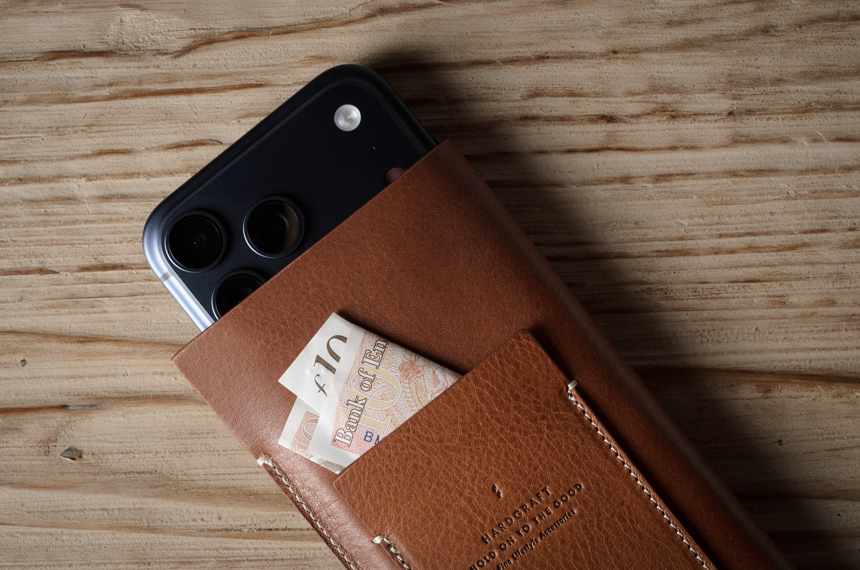 Brown leather iphone case with a card pocket on a wooden surface