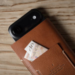 Brown leather iphone case with card holder on a wooden surface