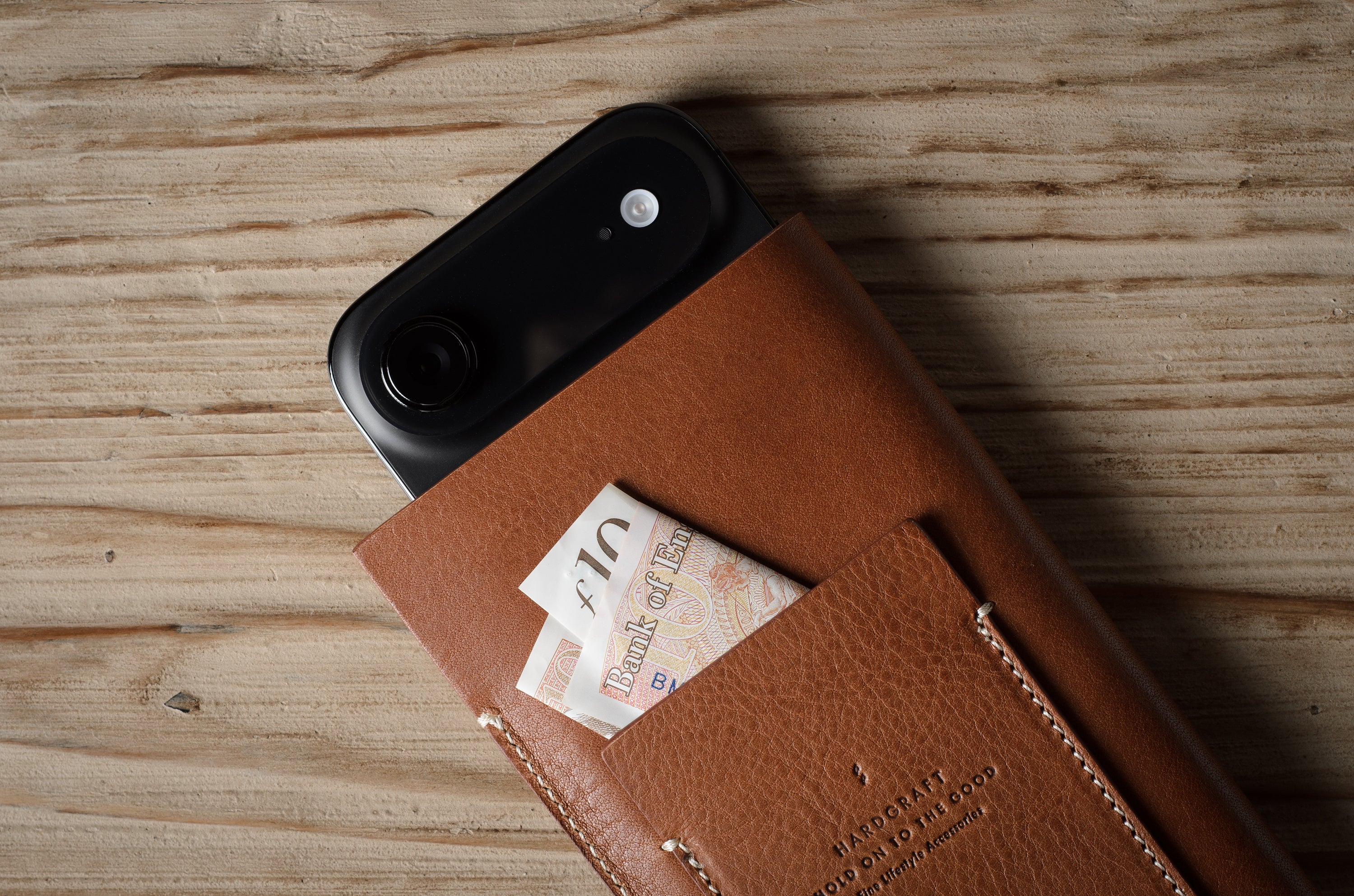 Brown leather iphone case with card holder on a wooden surface