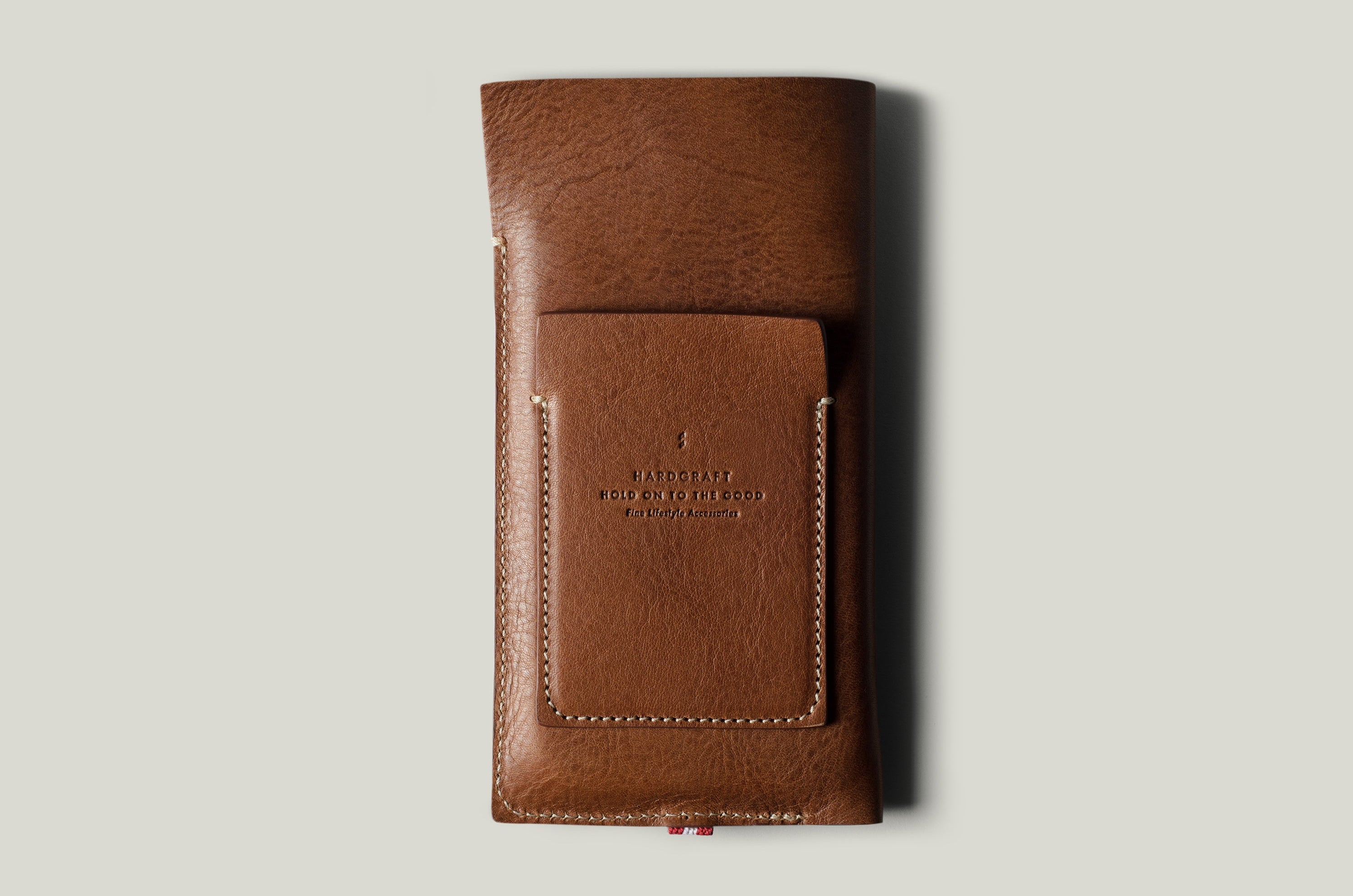 Brown leather  iphone case with brand embossing on a light gray background