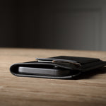 Black iphone case on a wooden surface with a blurred background