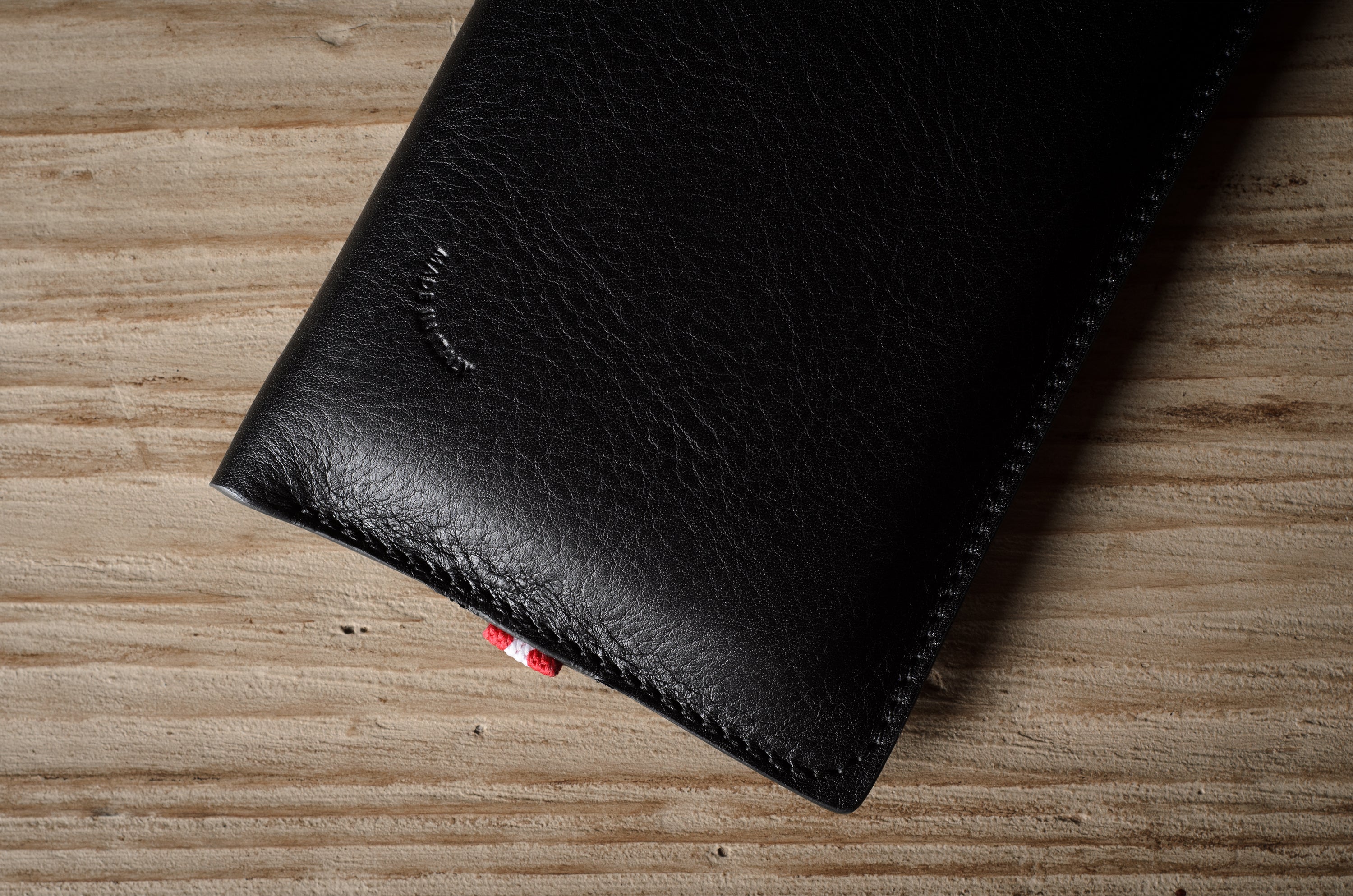 Black leather iphone case on a wooden surface