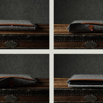 Gray wool felt laptop sleeve with brown leather on a wooden surface
