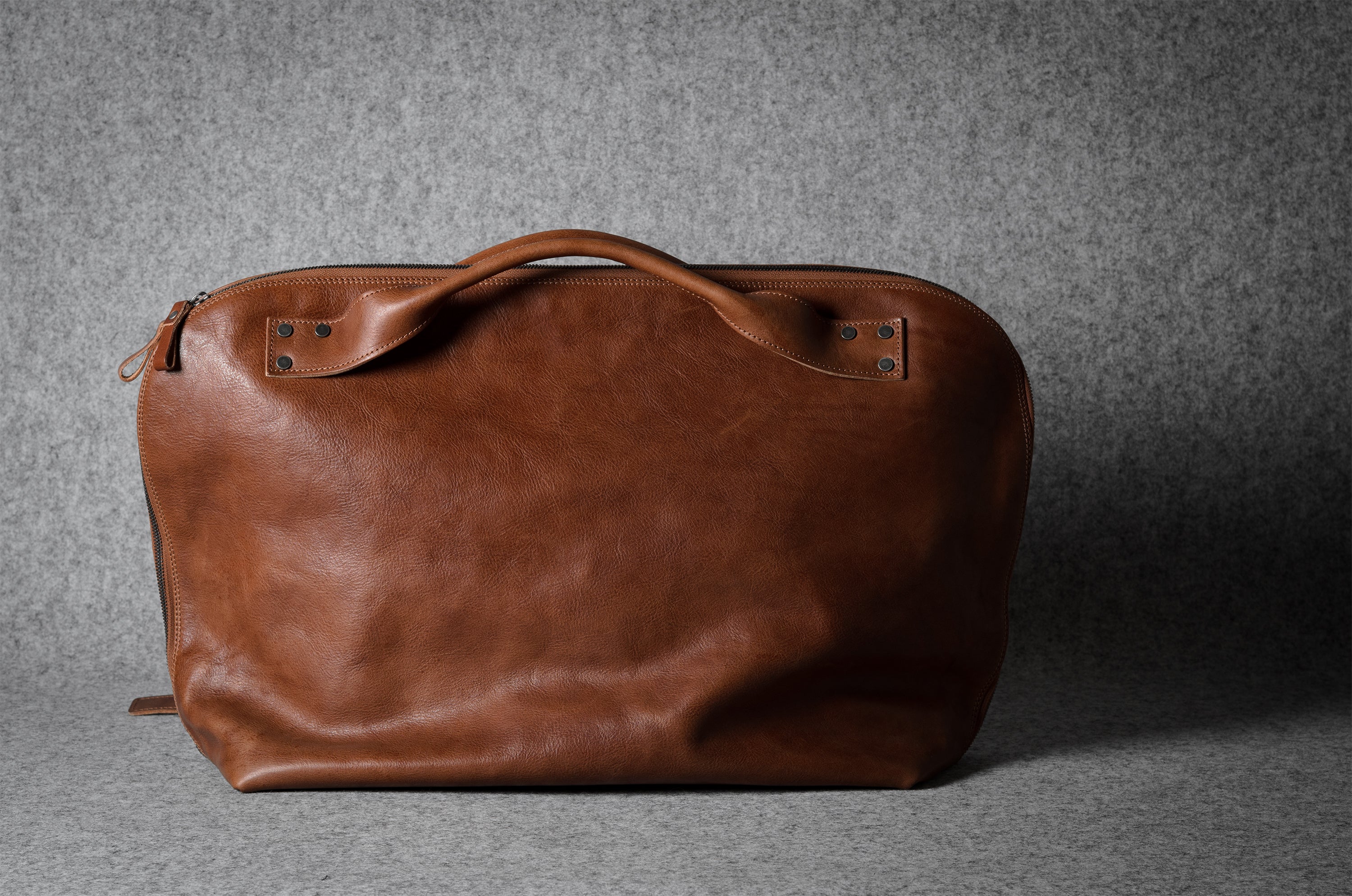 Brown leather bag on a gray background