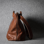 Brown leather bag on a gray background