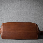 Brown leather bag on a gray background