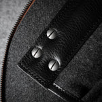 Close-up of a textured bag interior with a zipper and metal screws.