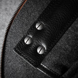 Close-up of a textured bag interior with a zipper and metal screws.