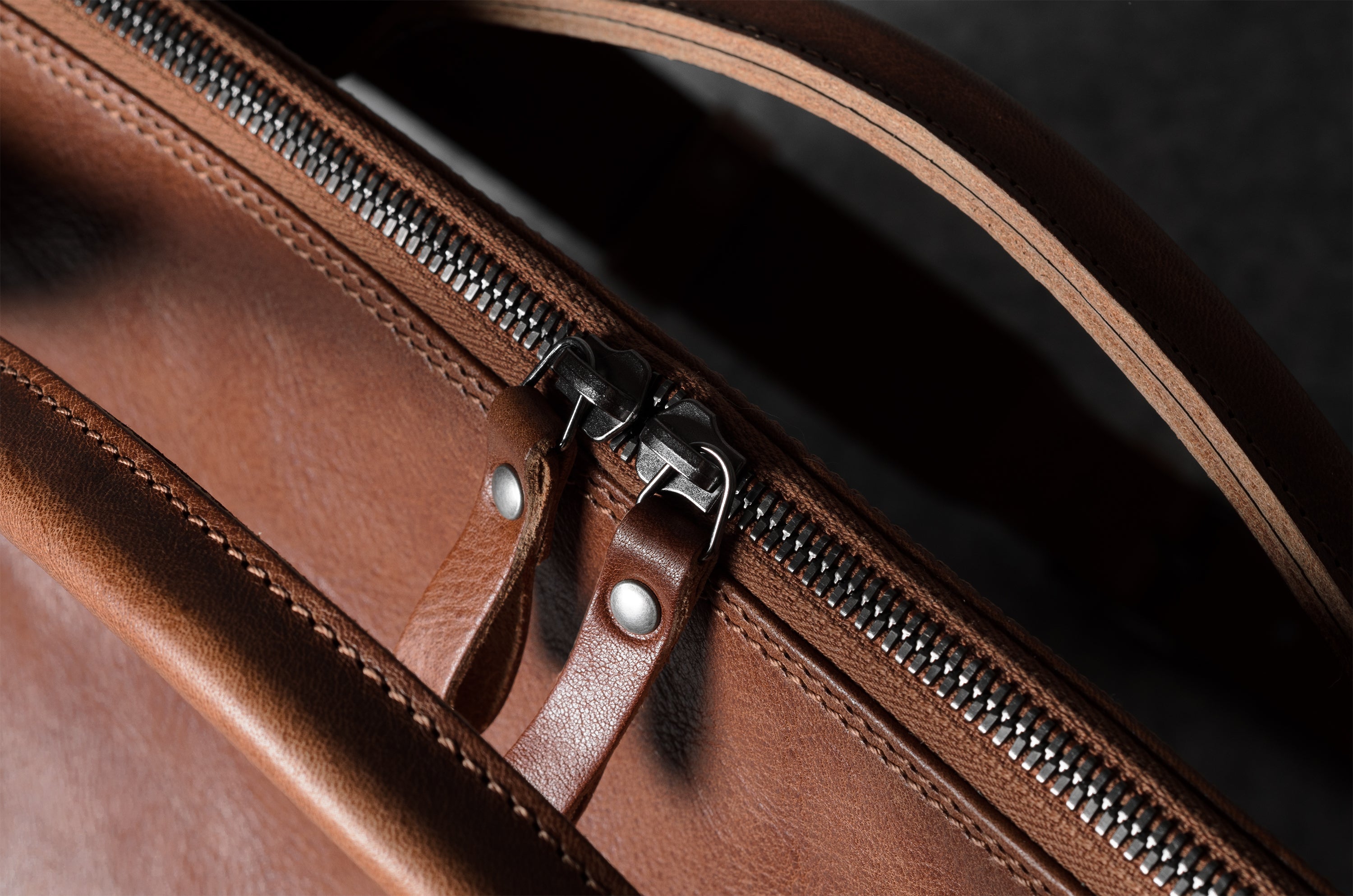 Close-up of a brown leather bag with a zipper