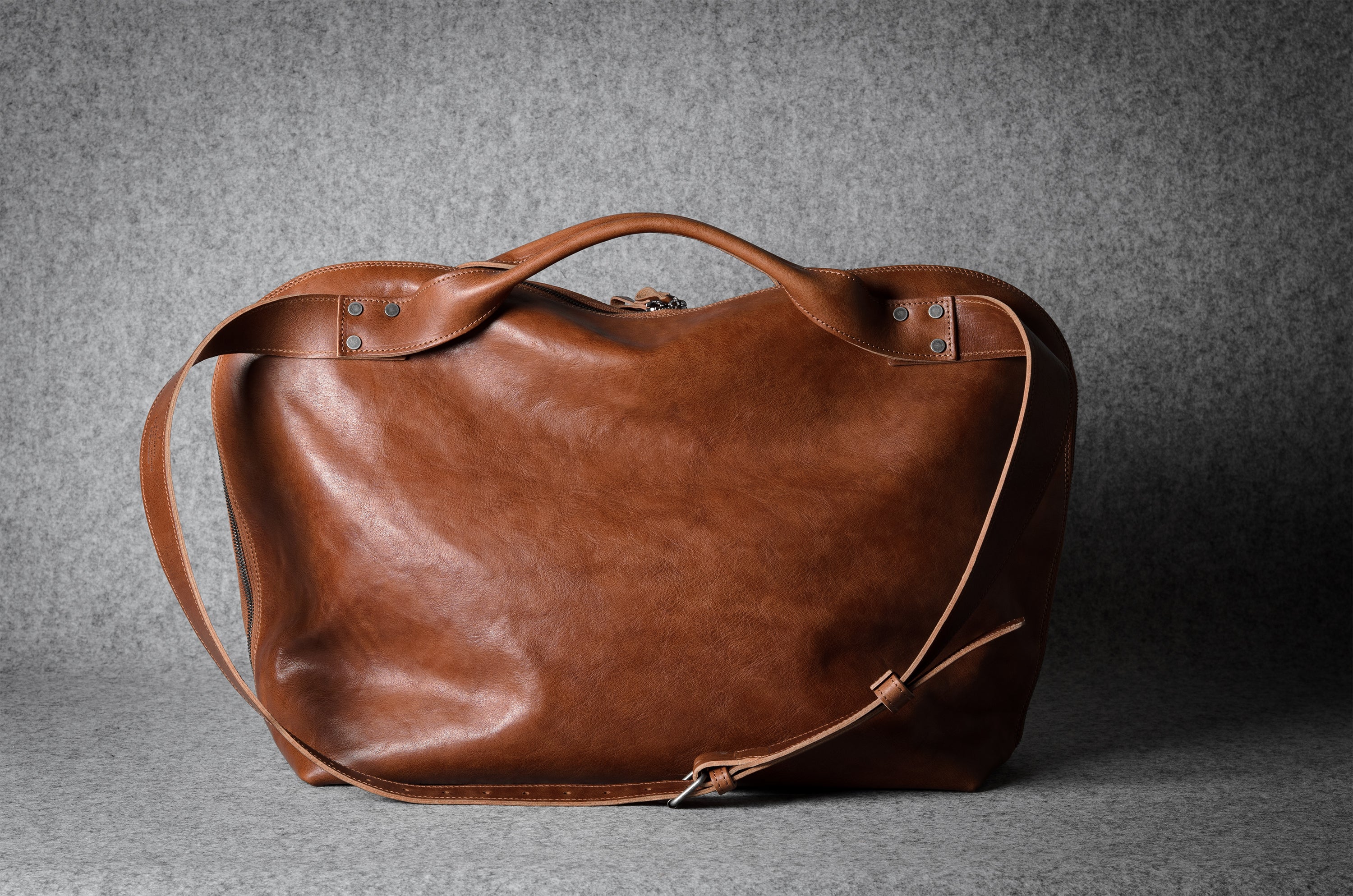 Brown leather bag on a gray background