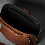Brown leather bag with a grey interior on a dark gray background