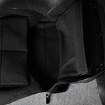 Black leather bag with a strap on a gray background