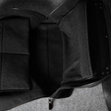 Black leather bag with a strap on a gray background