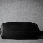 Black leather bag on a gray background