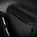 Black carrying case with a compartment for electronic devices on a dark background