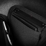 Black carrying case with a compartment for electronic devices on a dark background