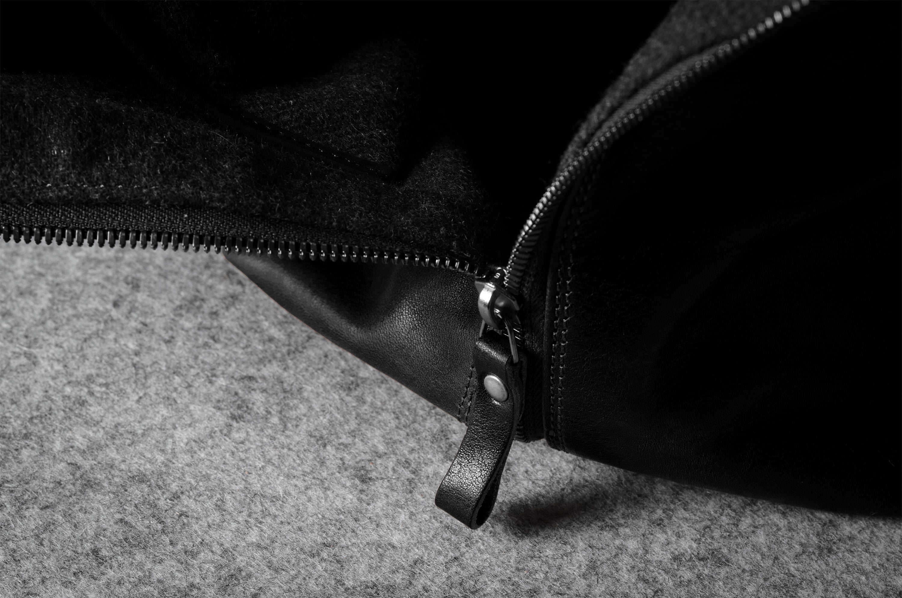 Close-up of a black zipper on a textured surface