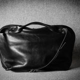 Black leather bag on a textured gray background