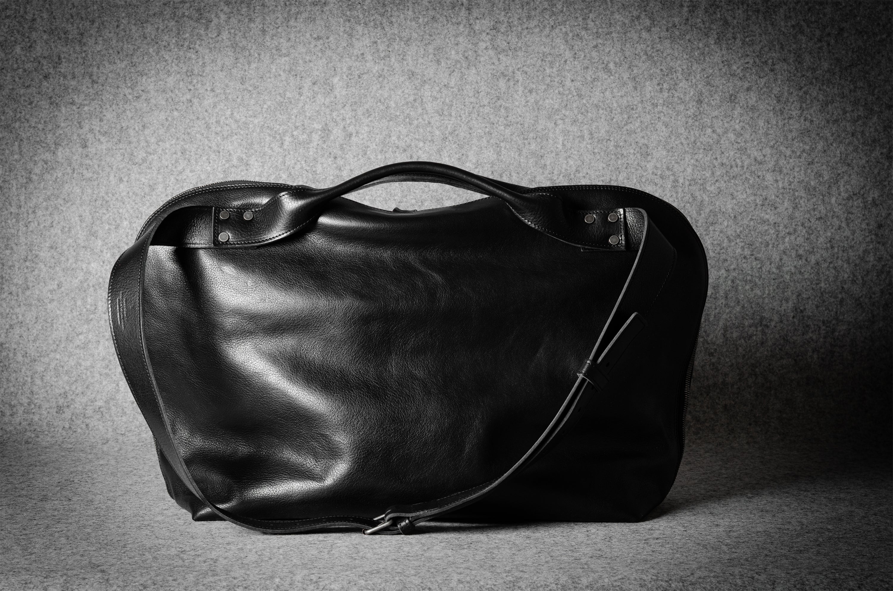 Black leather bag on a textured gray background