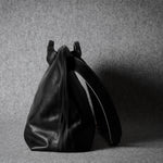 Black leather bag on a gray background