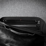 Black leather bag with a textured gray background