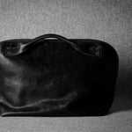 Black leather bag on a gray background