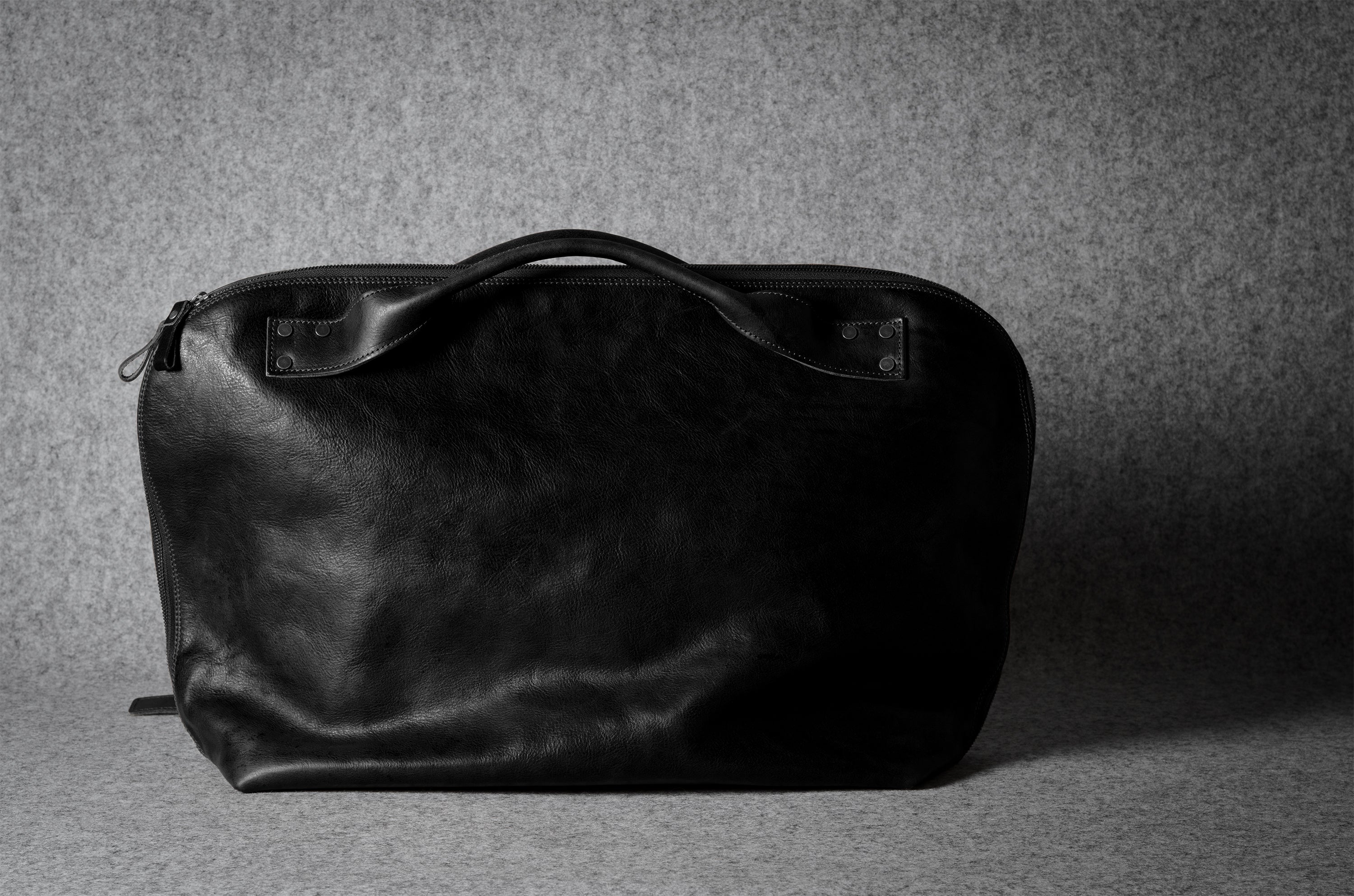 Black leather bag on a gray background